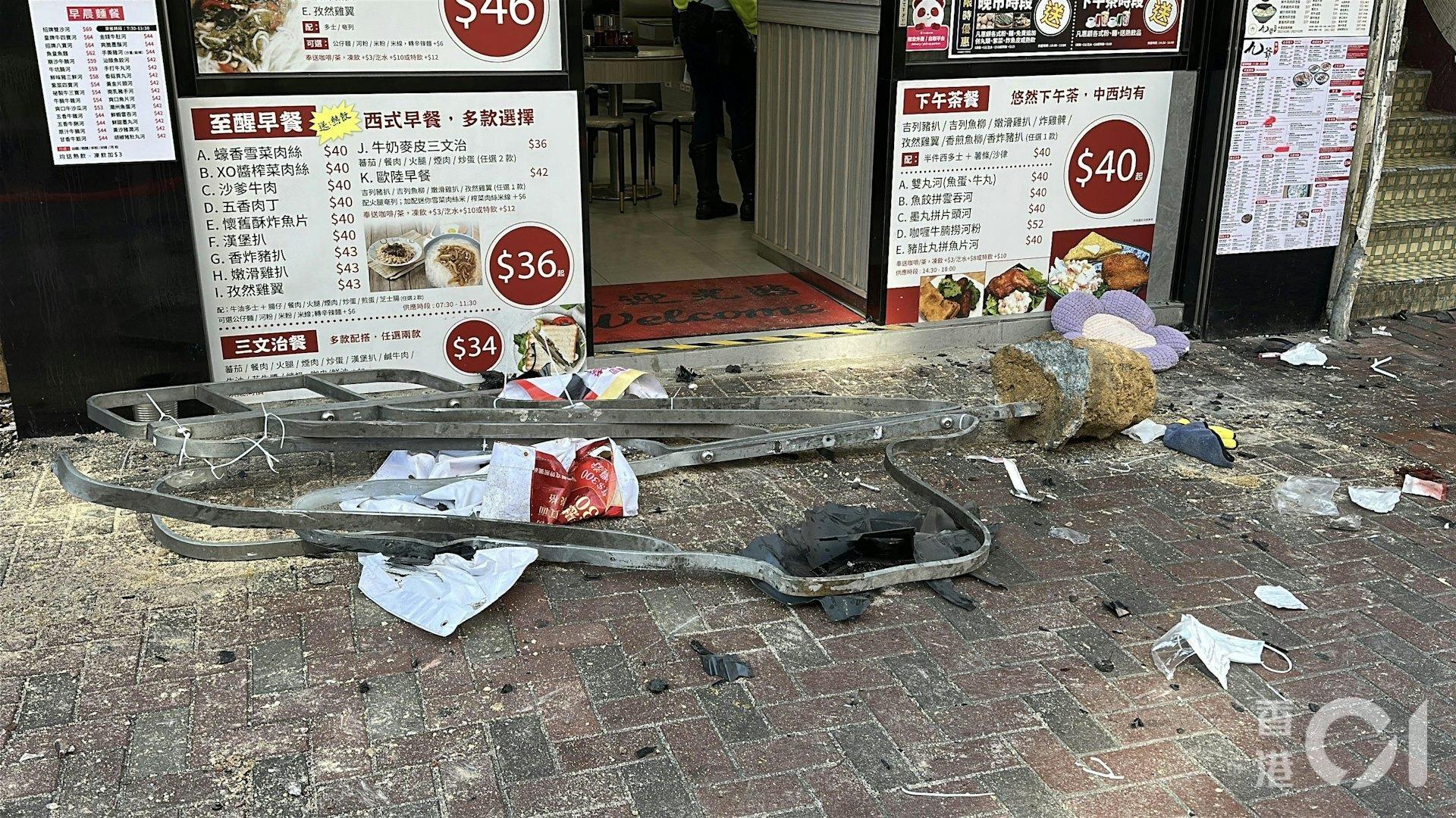 路邊鐵欄杆被撞彎,甚至倒在人行道、店舖門外,路面磚頭掀起。(圖/香港01)