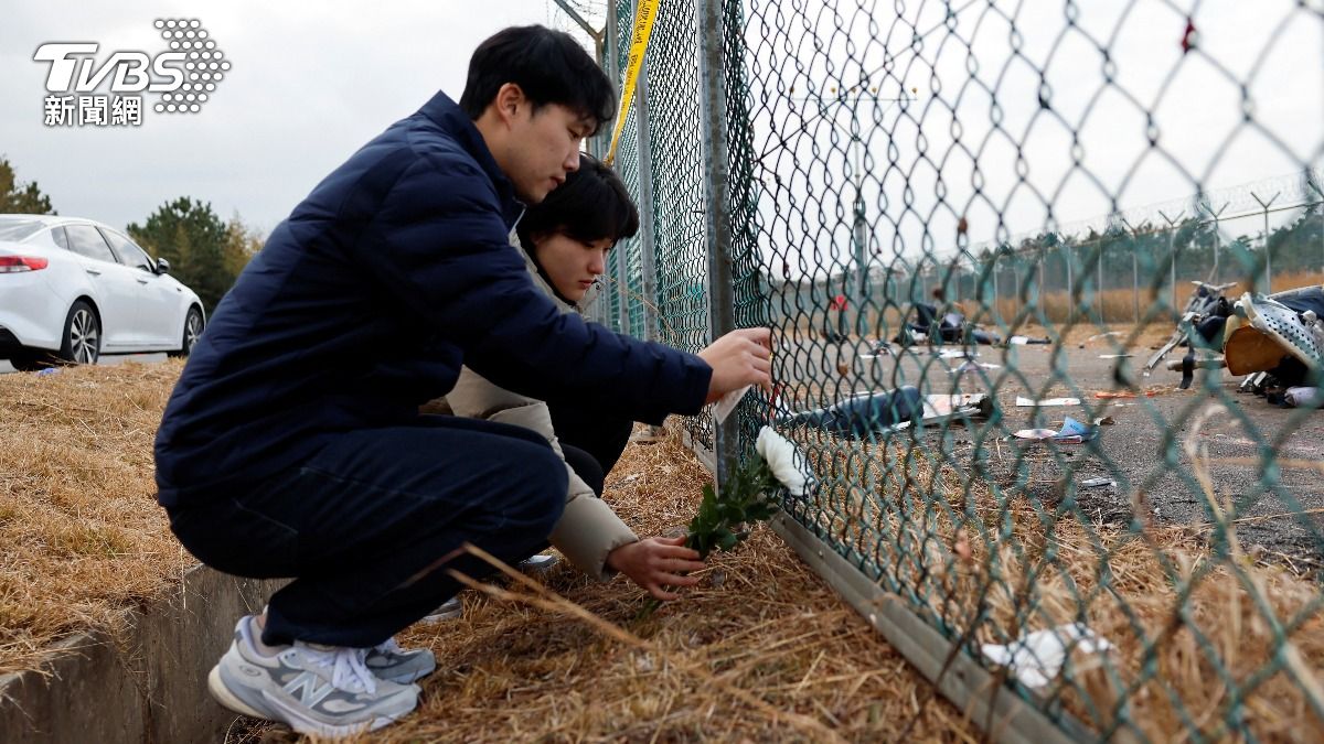 濟州航空空難附近也出現了悼念遇難者的菊花，和祈求亡者安息的紙條。（圖／達志影像路透社）