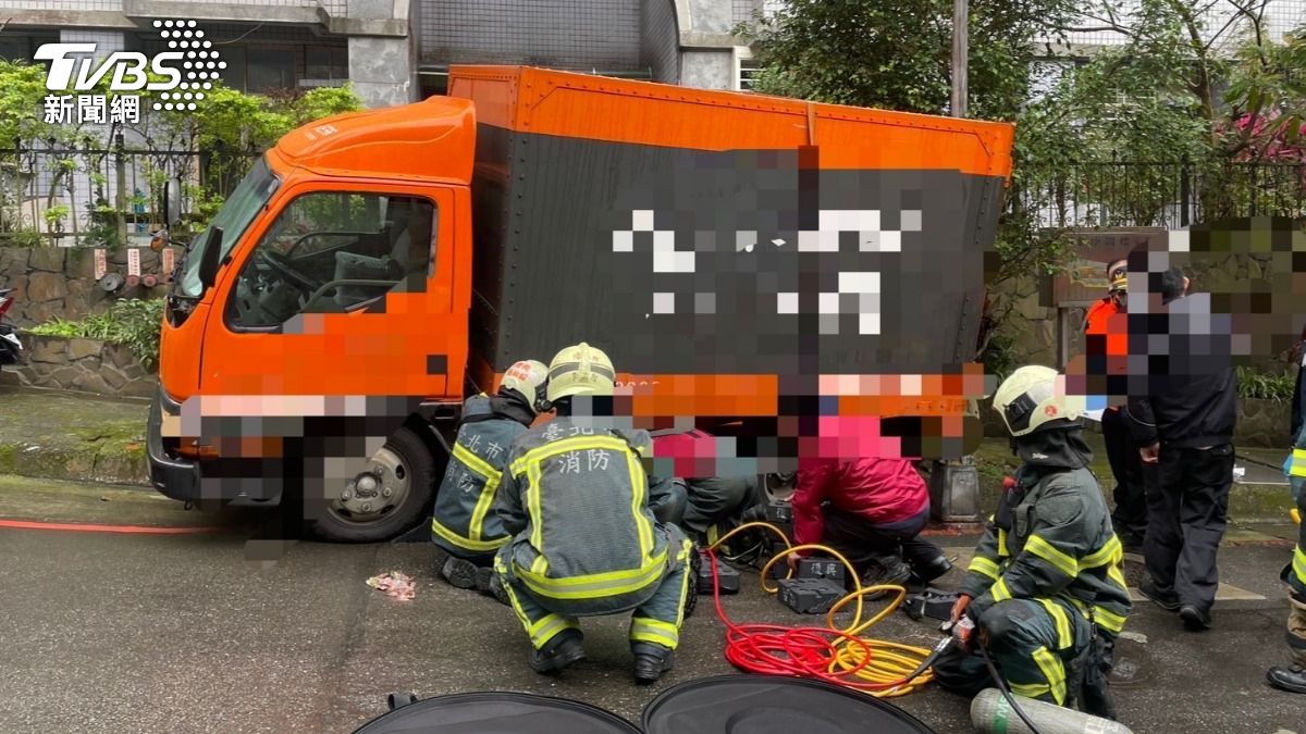 司機被滑行的貨車撞倒後受困車底,警消到場搶救。(圖/TVBS)