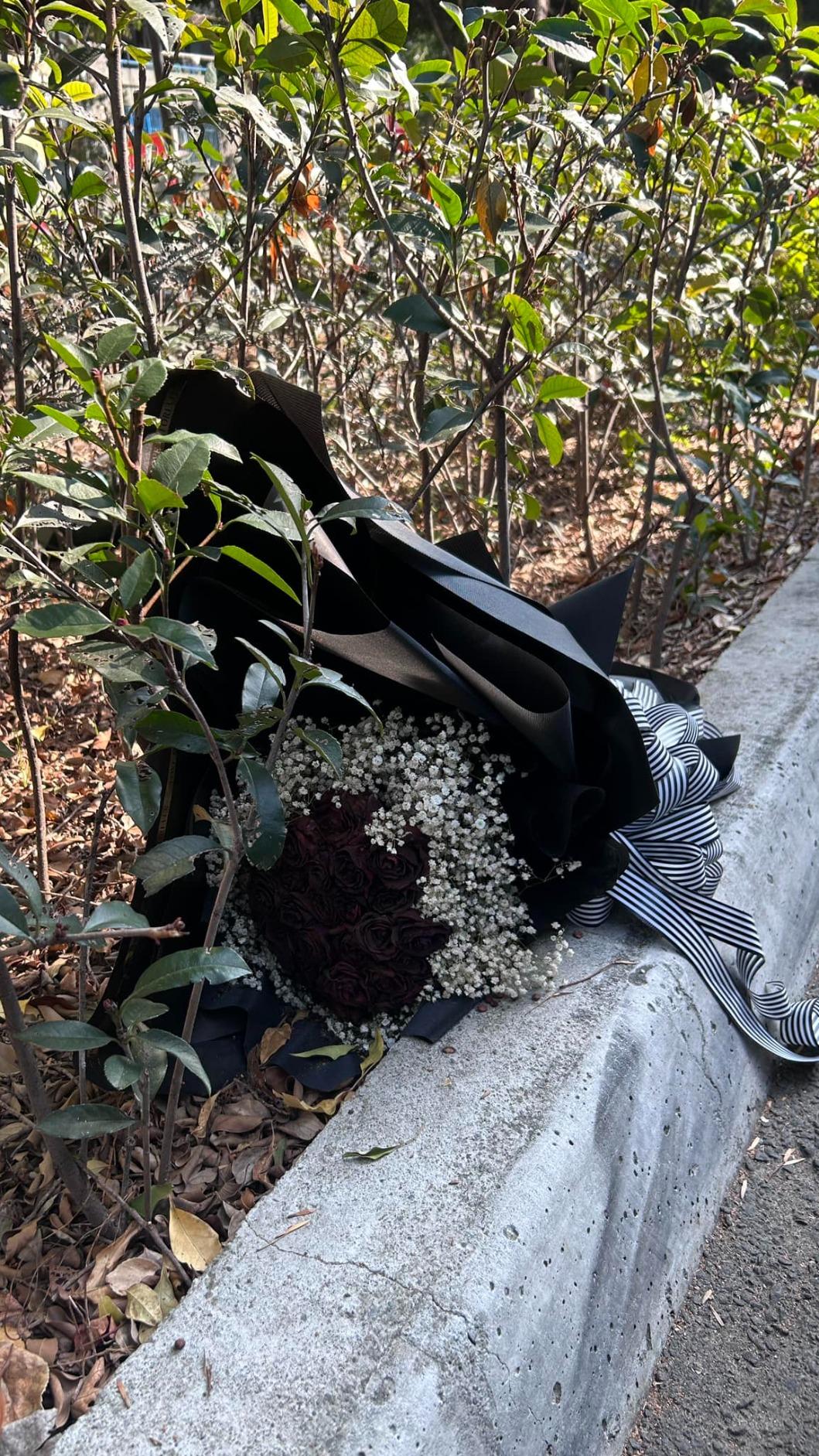 黑玫瑰花束被丟棄在公園樹叢邊。（圖／翻攝自路上觀察學院臉書）