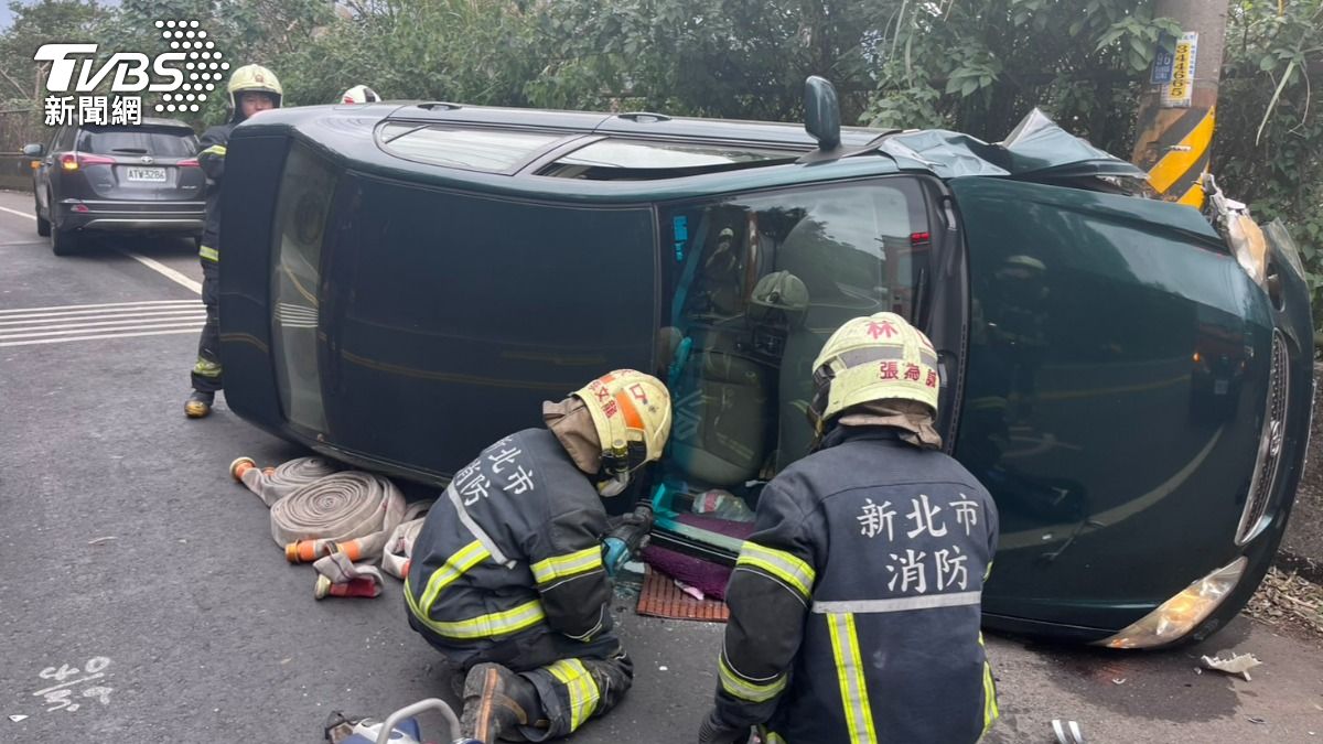 小轎車自撞翻覆,大批警消到場救援將受困的駕駛與乘客2人救出送醫。(圖/TVBS)