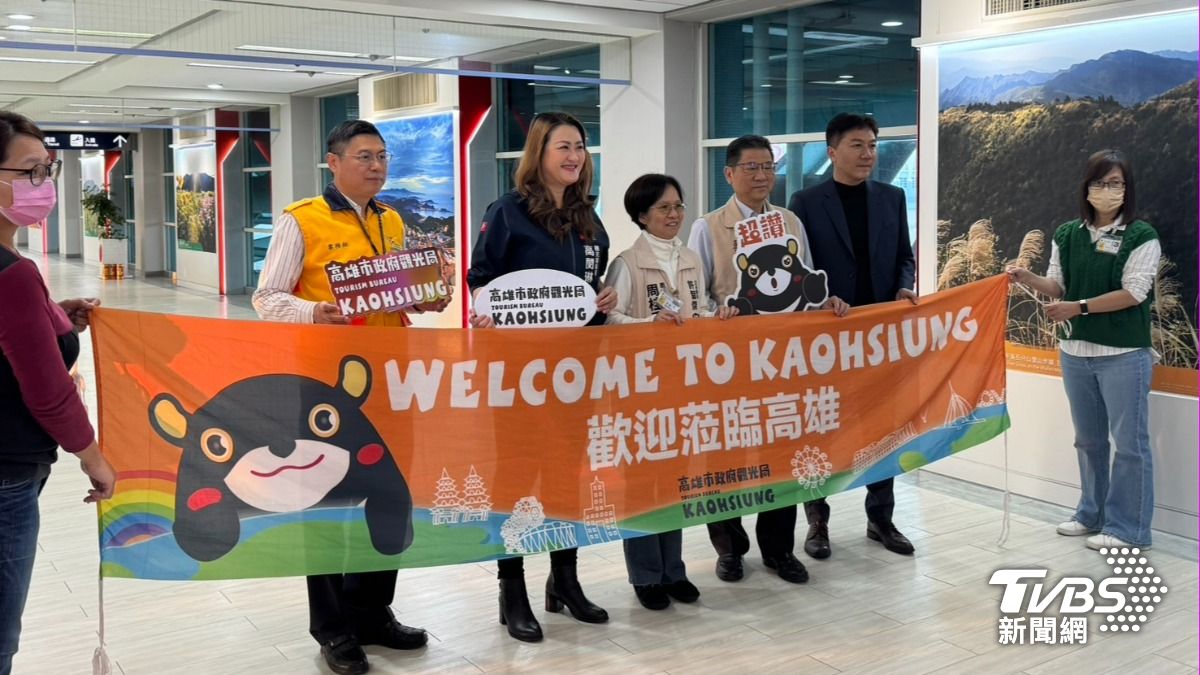 高閔琳及許智傑服務團隊在機場發上給首航旅客迎賓紀念品。(圖/林雅婷攝)