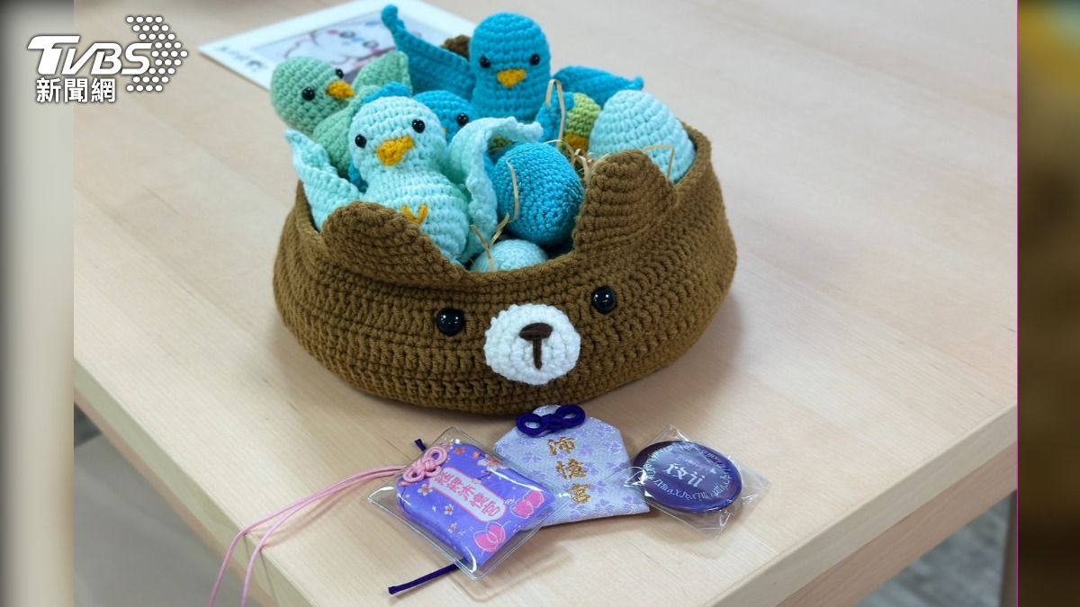粉絲製作「加開零食會」編織作品,熊代表沈伯洋,籃子裡的青鳥與蛋則代表支持者與福國利民的法案,象徵沈守護青鳥與法案。其他則為吳沛憶粉絲所做的御守及徽章。(圖/潘袁詩羽攝)