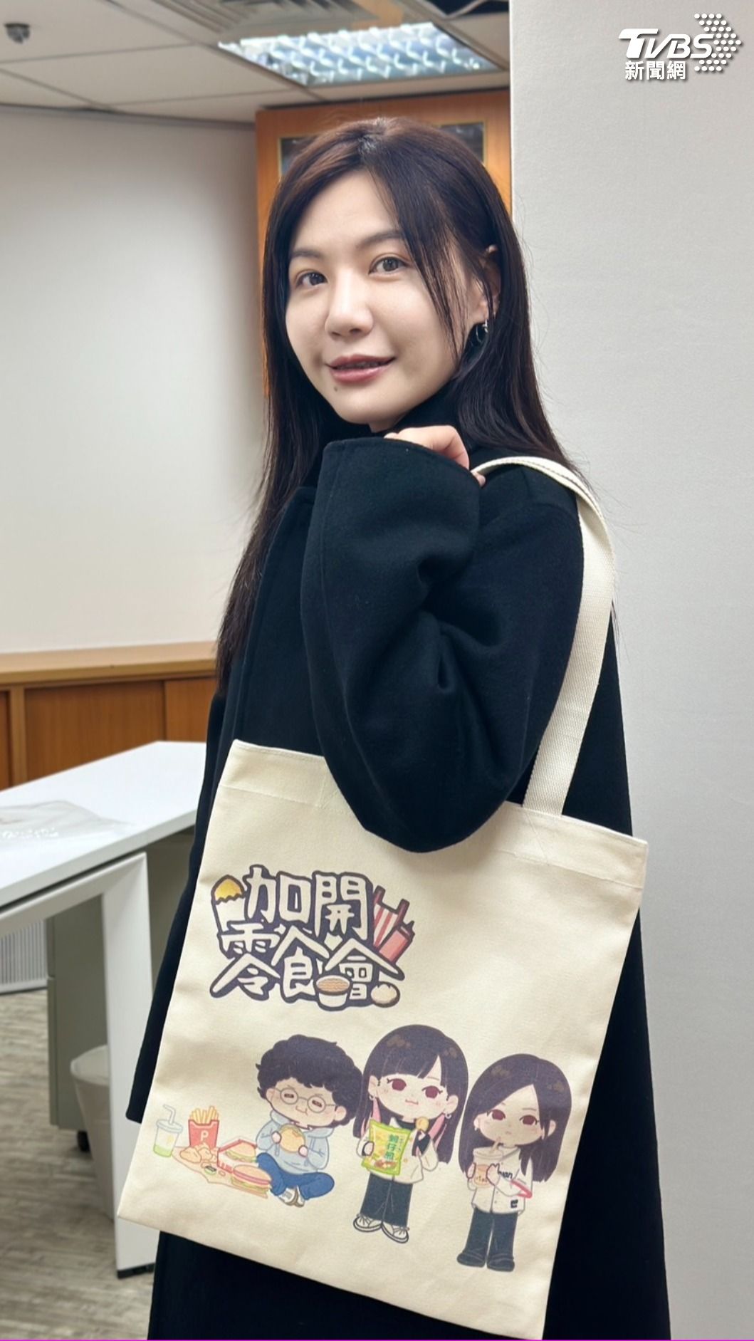 吳沛憶親自展示粉絲製作的托特包。(圖/潘袁詩羽攝)