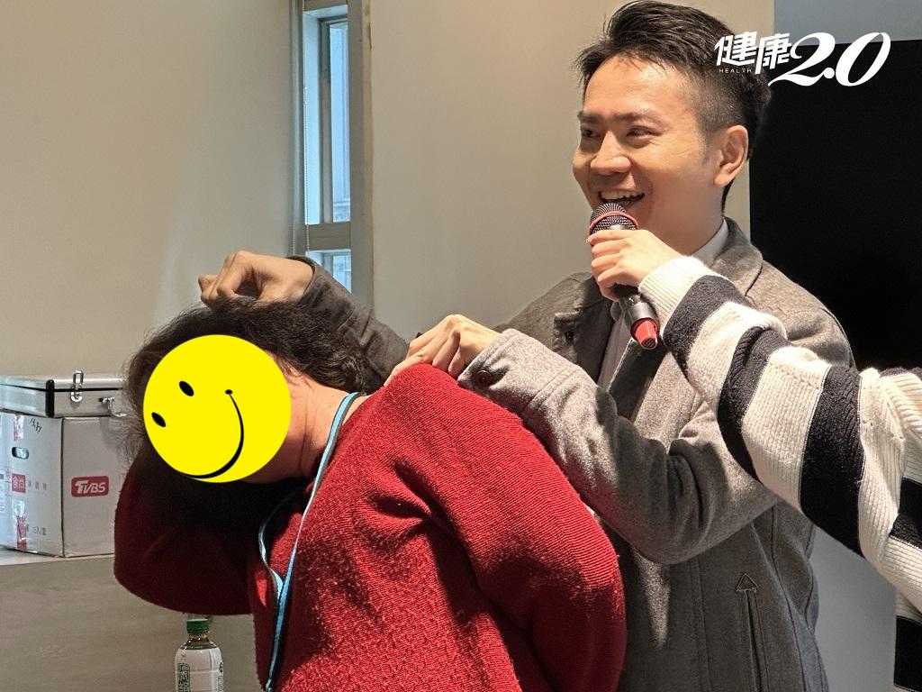 賴信甫中醫師帶領參與者實作拮抗拉筋法，透過頭部與手掌的力量抵抗，有效放鬆肩頸肌肉。（圖／健康2.0）