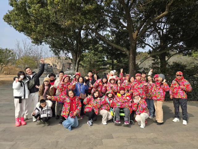 一家人穿著招牌大花制服合照。(圖/翻攝自「啟德機械起重工程-股公司」臉書)