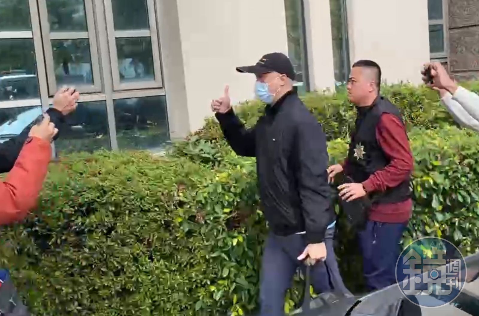 夏男在媒體簇擁下、比出「讚」手勢。