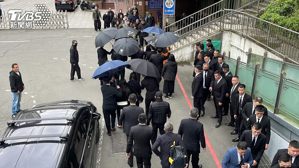 大批黑衣人列隊護送黃少岑前往慈恩園。(圖/潘建樺攝)