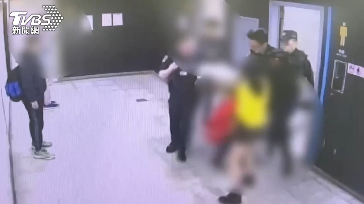 員警將醉倒的洪男攙扶出男廁。(圖/TVBS)