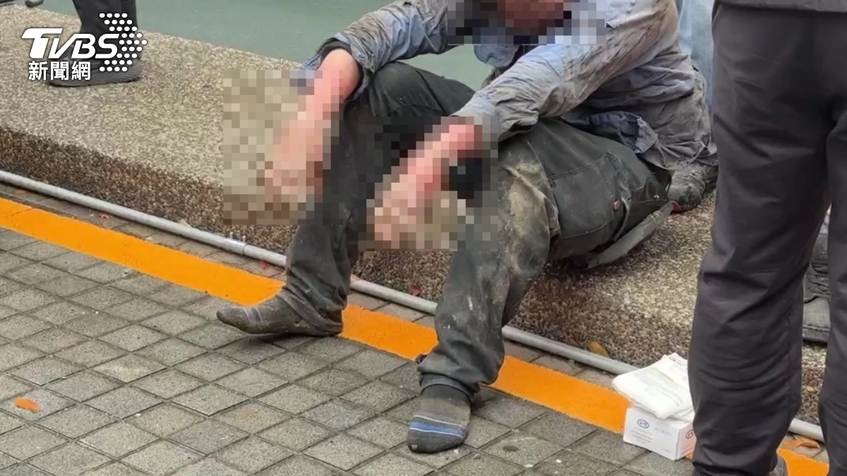 施工人員雙手嚴重燒傷坐在路邊等待救援。(圖/TVBS)