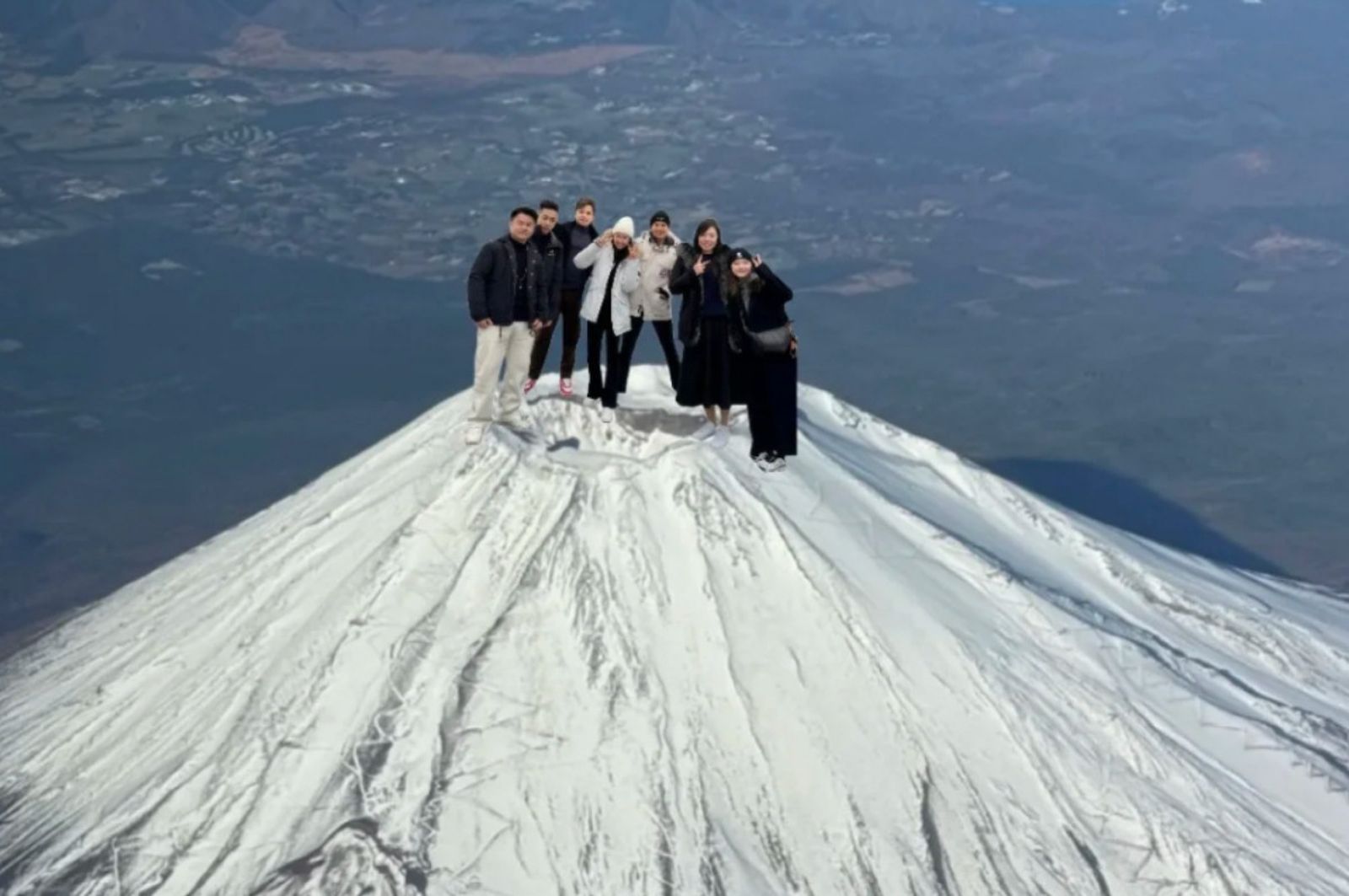 中國網友炫耀登頂富士山，可是照片比例失真，被網友嘲笑每個人都是巨人。（翻攝微博）