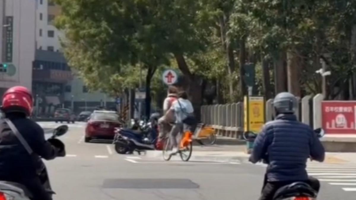2男子跨坐車籃共乘Youbike。(圖/翻攝社會事新聞影音)