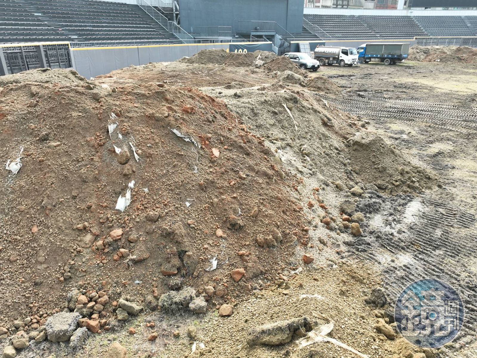 新竹市立棒球場啟動覆土移除作業後,外野區域挖出大量混凝土石塊,夾雜塑膠製品、廢電線、紅磚等營造廢棄物。(圖/讀者提供)