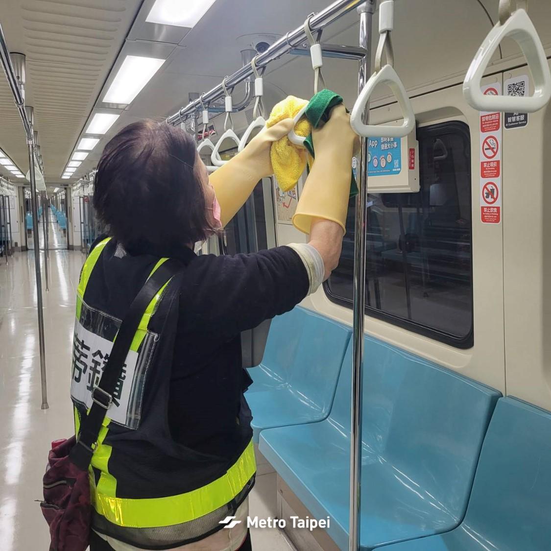 清潔人員細心擦拭扶手。(圖/翻攝自FB 台北捷運 Metro Taipei)