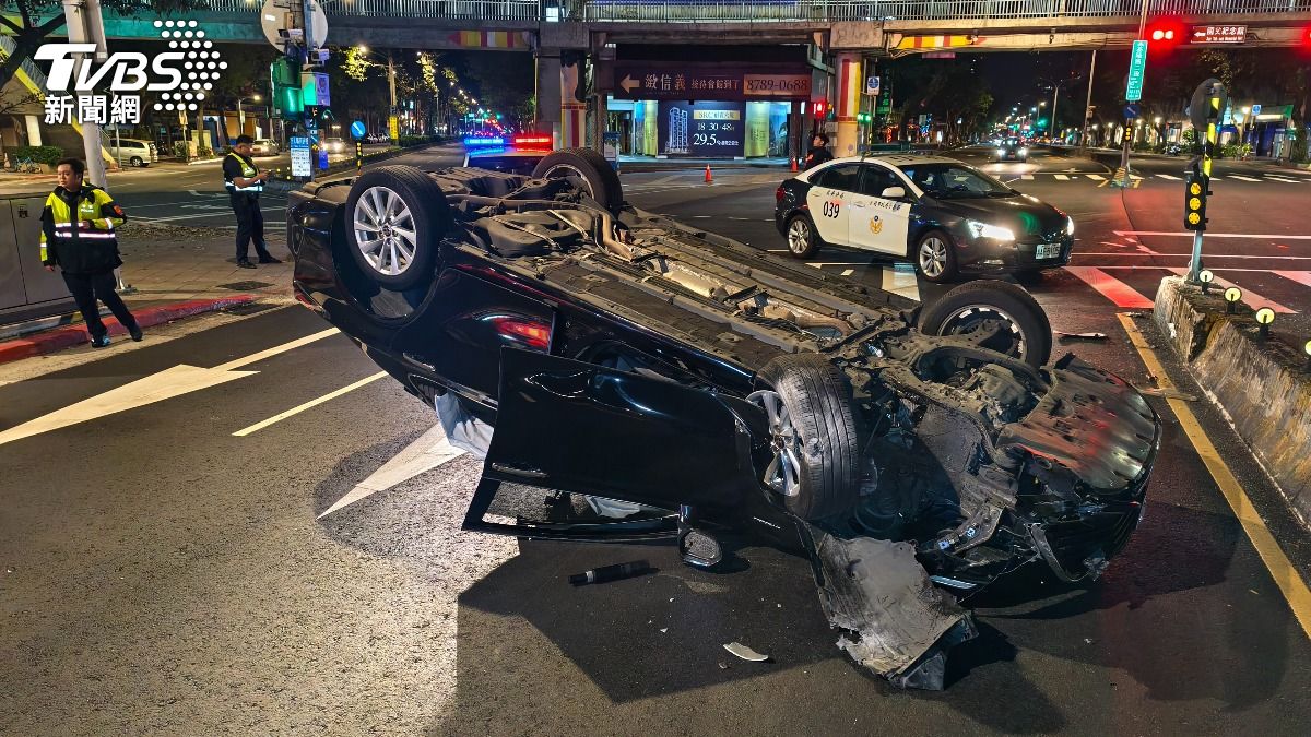 車輛翻覆後四輪朝天,2名乘客從後座爬出。(圖/陳冠宇攝)