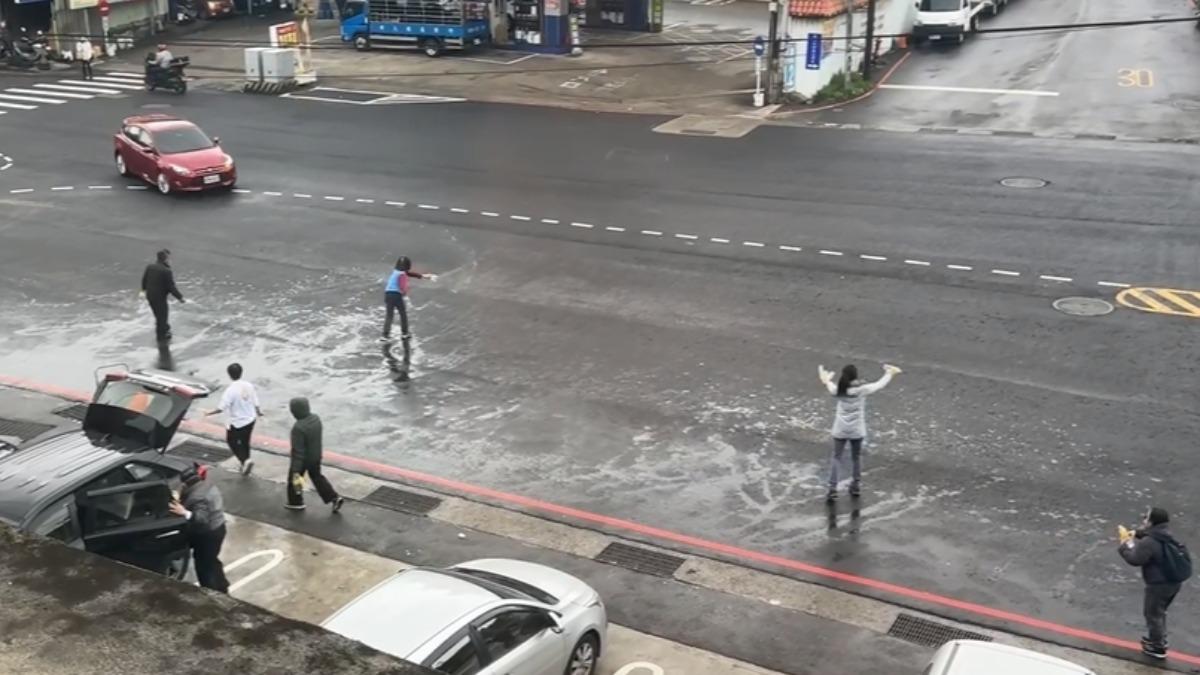 民眾闖馬路灑水時車輛經過。(圖/翻攝Threads abobooa)
