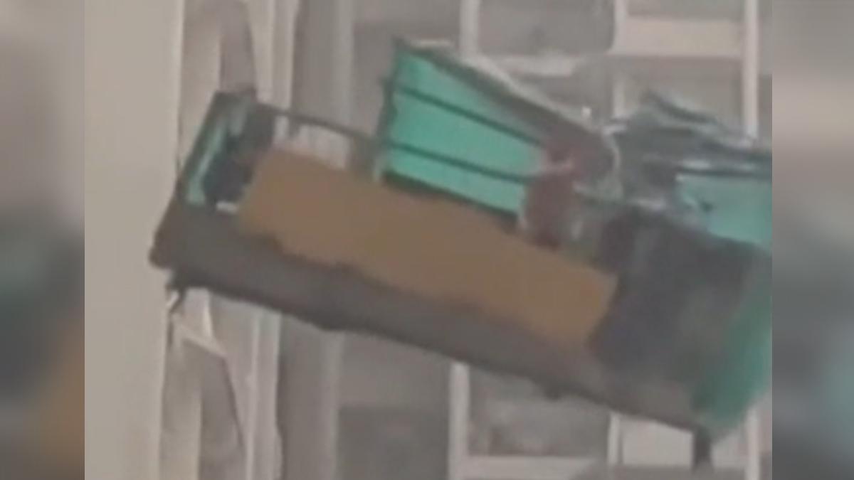 香港15日下午突然出現狂風暴雨,一名洗窗工人被卡在10層樓高的洗窗機上,場面相當驚險。(圖/網路)