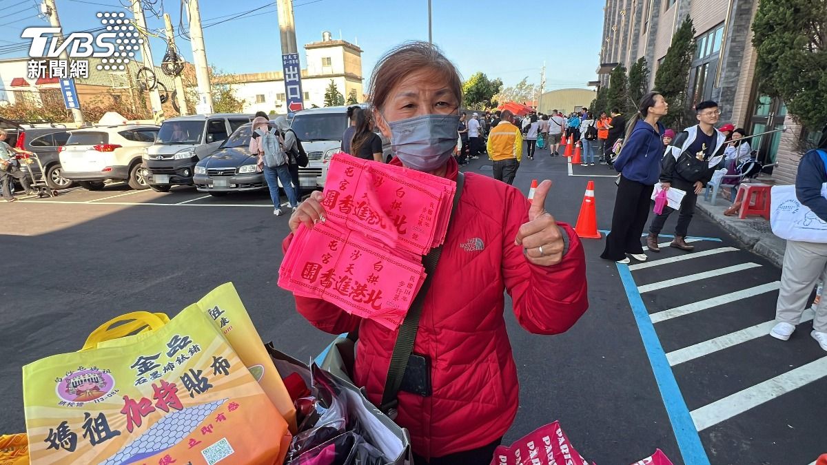 苗栗縣通霄鎮白沙屯拱天宮媽祖一年一度往北港進香活動27日上午受理報名，有香燈腳為自己及親友完成報名，開心秀出臂章。（圖／中央社）