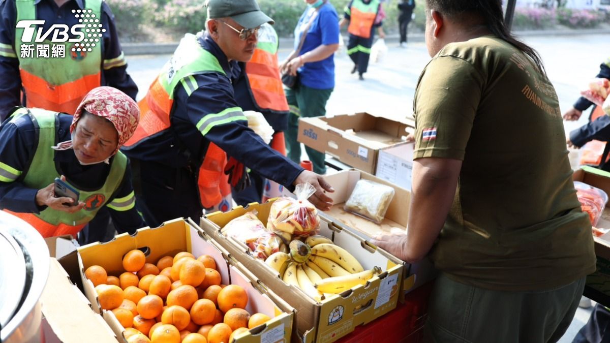 志工將各地捐贈物資運入場內。（圖/華子琛攝）