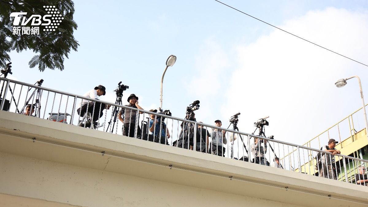 媒體聚在倒塌大樓旁天橋上拍攝殘骸拆除情況。（圖/華子琛攝）