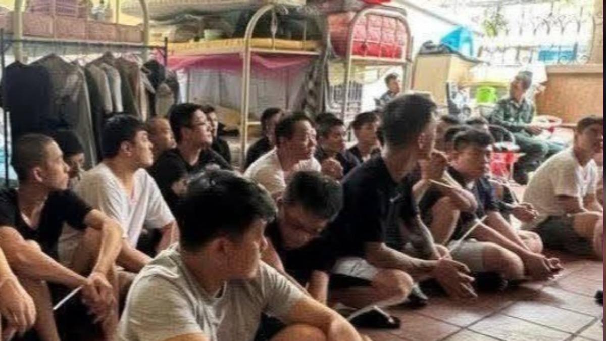 眾人被逮時坐在床架前。(圖/翻攝自柬中時報)