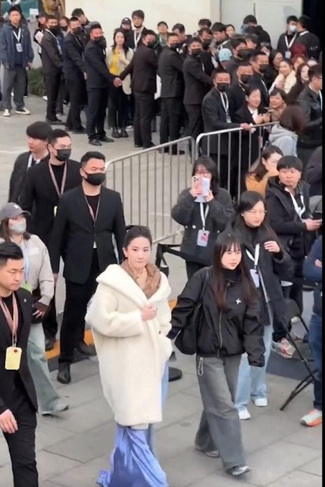 保安人員幾乎同步回望劉亦菲。(圖/微博圖片)