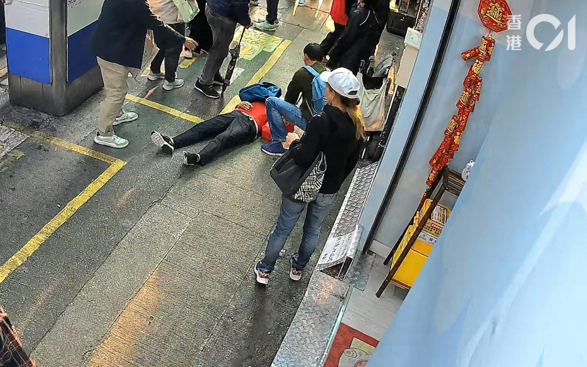 女事主向後跌倒後,倒地不起,多名路人上前協助。(圖/香港01)