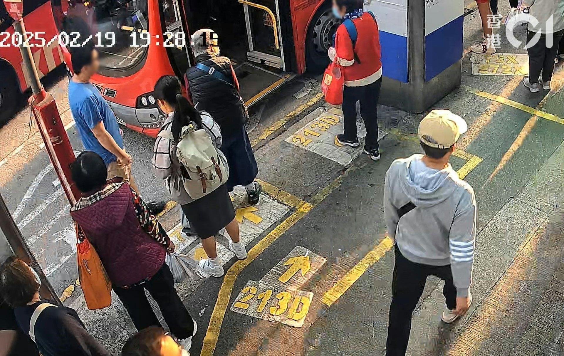 身穿紅衣的婦人準備登上巴士,一名藍衣眼鏡男子從路邊走近。(圖/香港01)