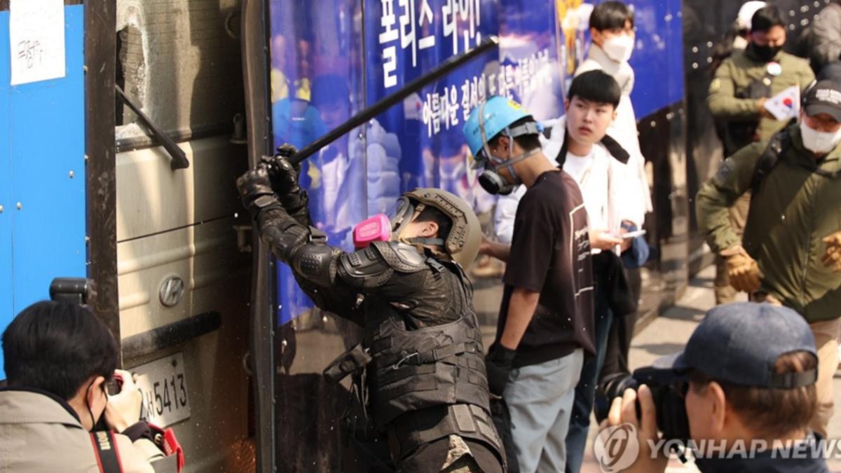 一名尹錫悅支持者,持警棍破壞警察車輛。(圖/翻攝自韓聯社)
