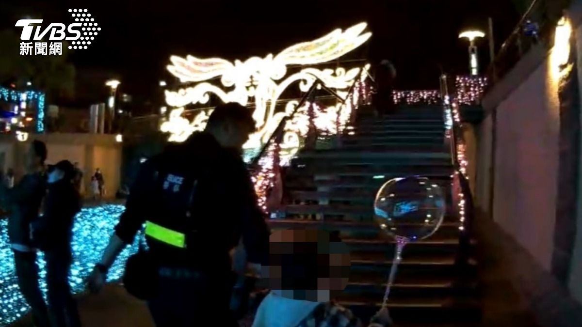 員警化身親和力十足的大哥哥，暖心地牽著走失男童。（圖／TVBS）