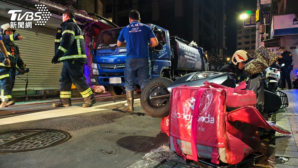 鍾女救出送醫後,警消合力將卡在車底的外送機車拉出移至路旁。(圖/陳冠宇攝)