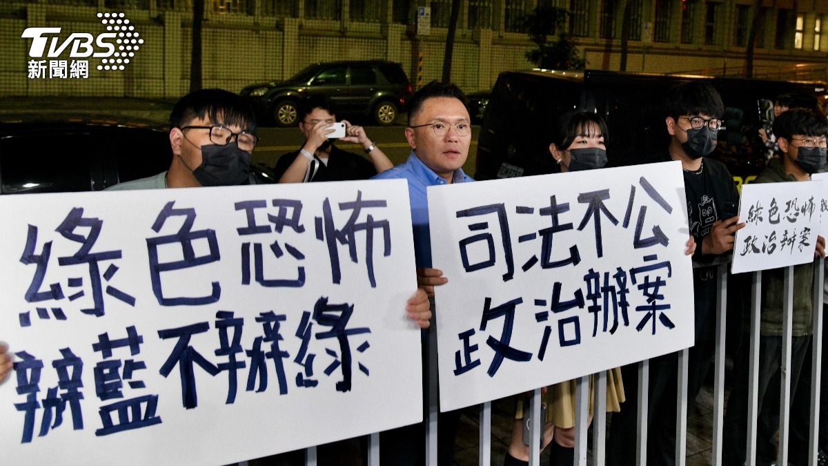 國民黨青年團成員在北檢外舉牌嗆檢調搜索罷吳團體成員是政治辦案。(圖/胡瑞麒攝)