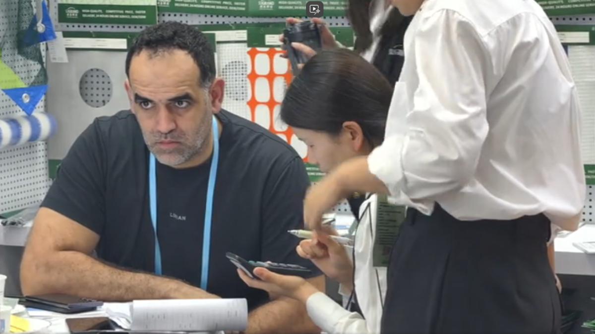 廣交會現場 外國採購商用手機翻譯（圖／TVBS）
