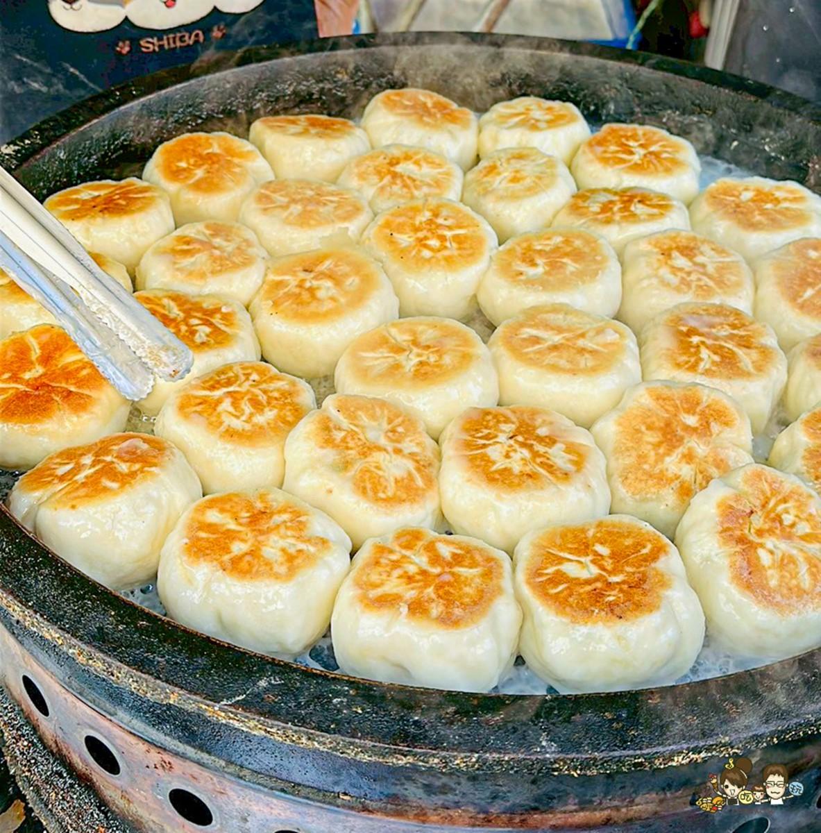 大鐵鍋擺滿煎至金黃色的水煎包、煎餅,看起來相當可口。(圖/跟著尼力吃喝玩樂提供)