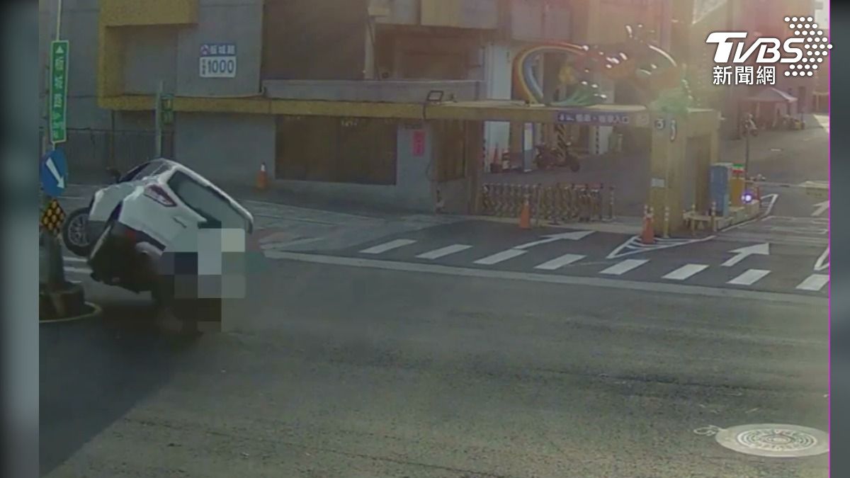 板橋果菜市場前，轎車壓庇護島翻覆。（圖／TVBS）