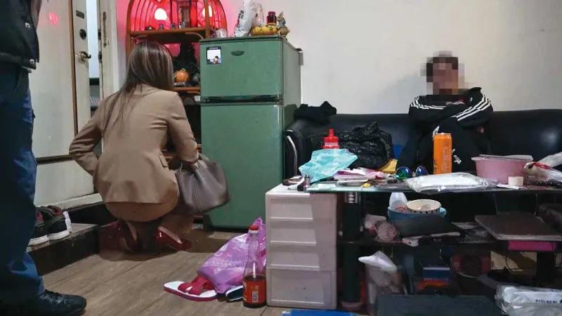檢警去年底到張男租屋處搜索,張男(右)被要求坐在椅子上等候。(圖/翻攝畫面)