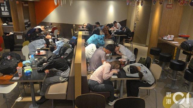 北京道的麥當勞分店有大約50人「留宿」，趴在桌上休息。（圖／香港01）
