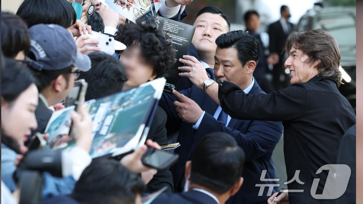湯姆克魯斯在金浦機場外熱情為粉絲簽名合影。(圖/news1提供)