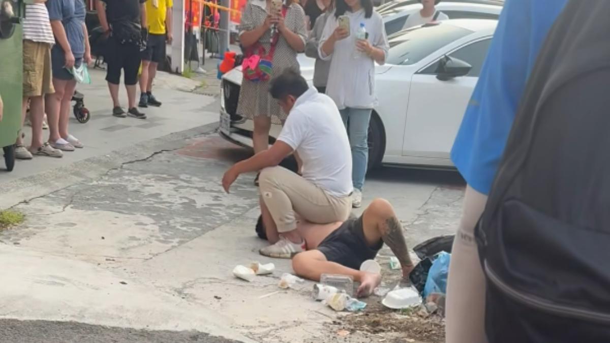 男子壓制在另一人身上,雙方後被警方依違反《社會秩序維護法》偵辦。(圖/翻攝自臉書)
