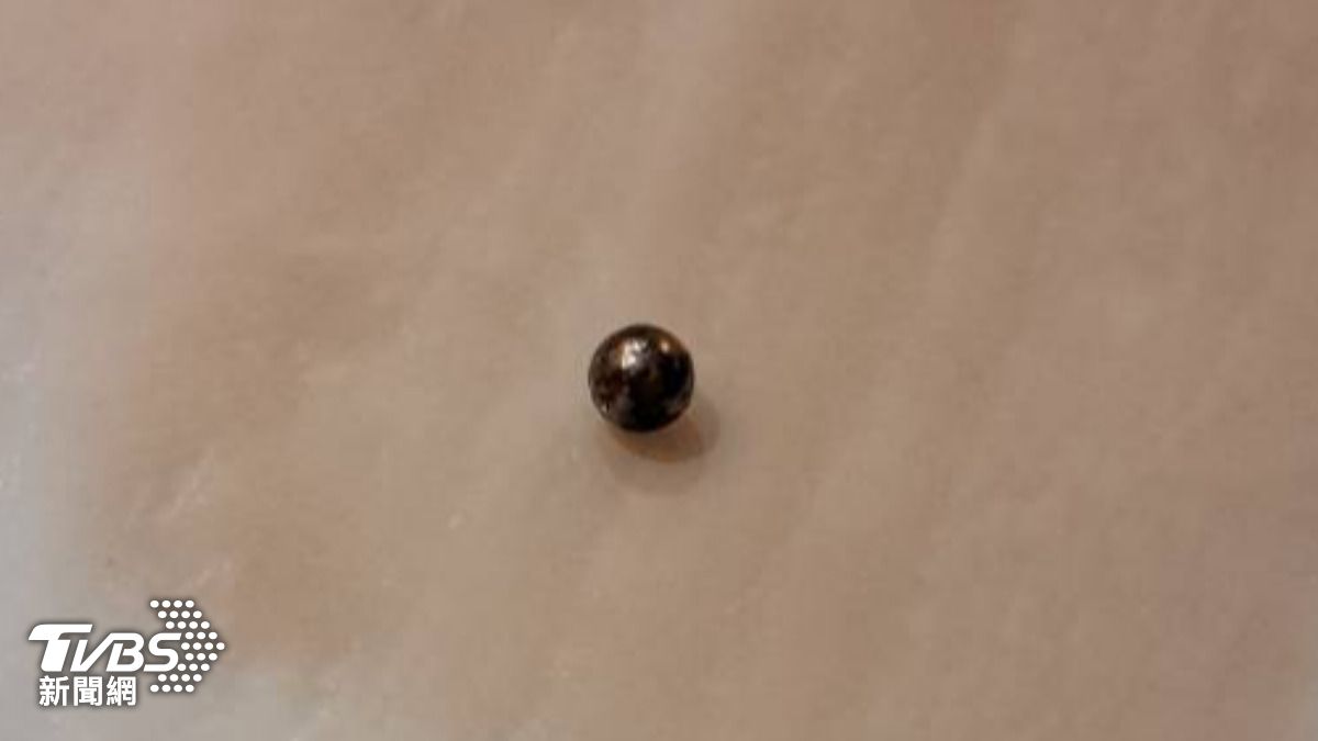 鋼珠貫穿玻璃窗戶後，掉落在發沙附近，目前警方已鎖定一名嫌犯。（圖／投訴人提供）