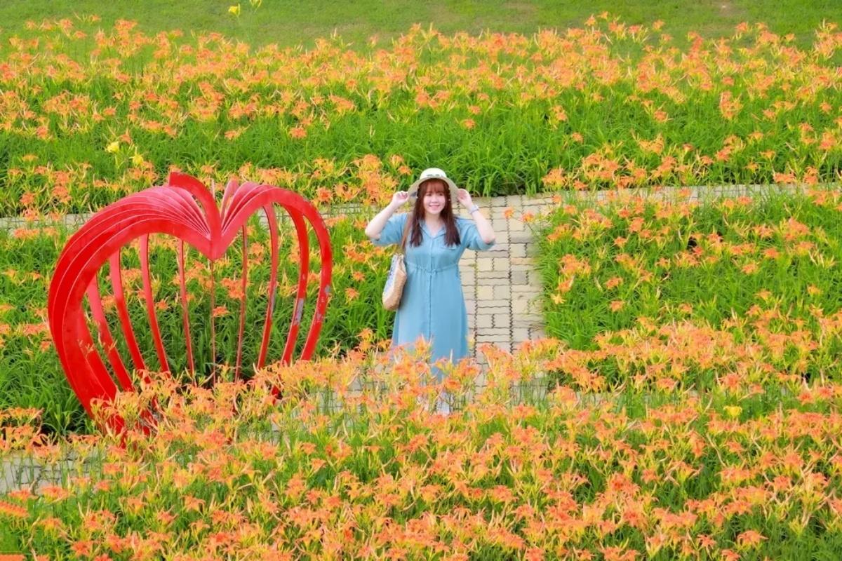 「后里環保公園」種植橘紅色品種的「日月潭3號金針花」,搭配裝置藝術超好拍。(圖/GO阿綸@旅人狂潮提供)