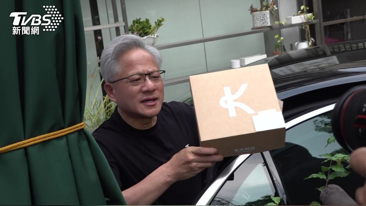黃仁勳理髮完手中拿一個紙盒，盒中是他最喜歡的杏仁可頌。（圖／TVBS）