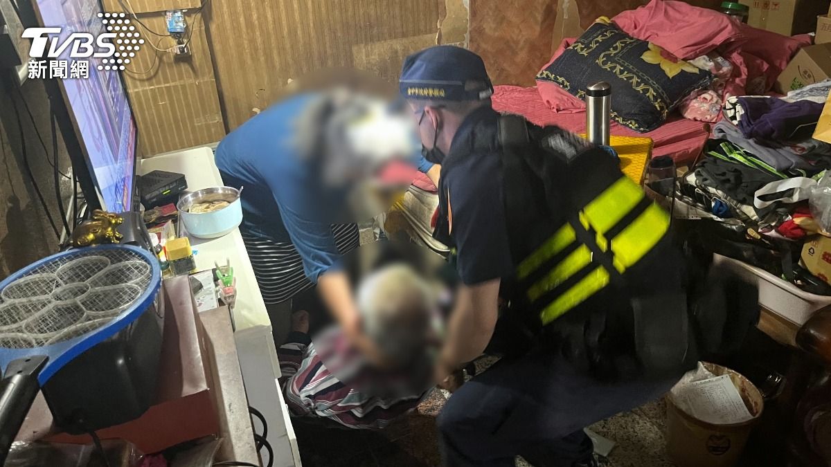 第三分局警方也在雜物堆中，將中風的丈夫扛起。（圖／TVBS）