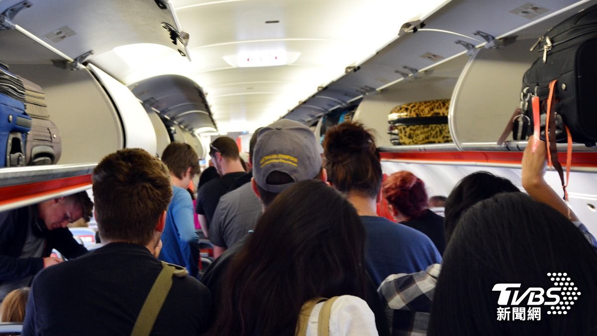 飛機一落地就急著起身、搶佔走道拿行李相當惱人。（示意圖／達志影像shutterstock）