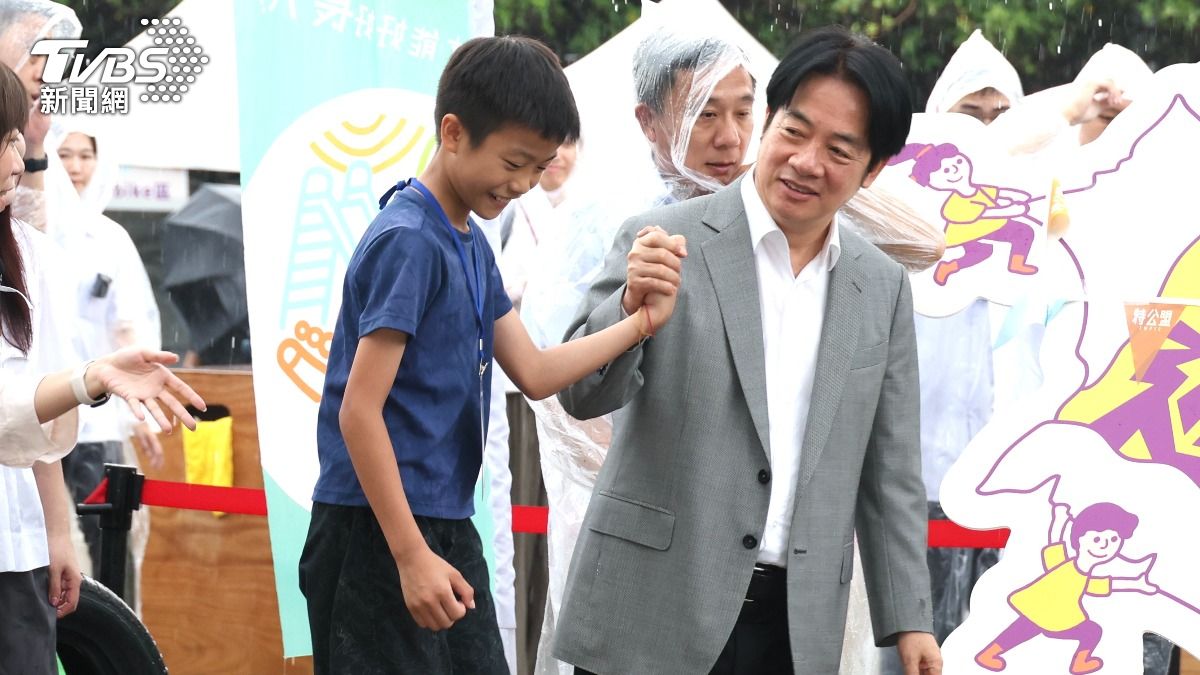 賴清德在大雨中陪孩童玩耍。（圖／華子琛攝）