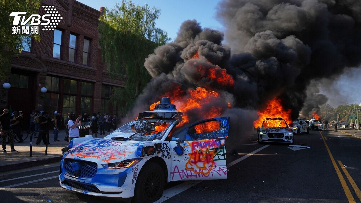 美國洛杉磯出現示威亂象,抗議者跳上警車踩破擋風玻璃,當街縱火燒垃圾桶,還有駕駛開車撞人群。(圖/達志影像美聯社)