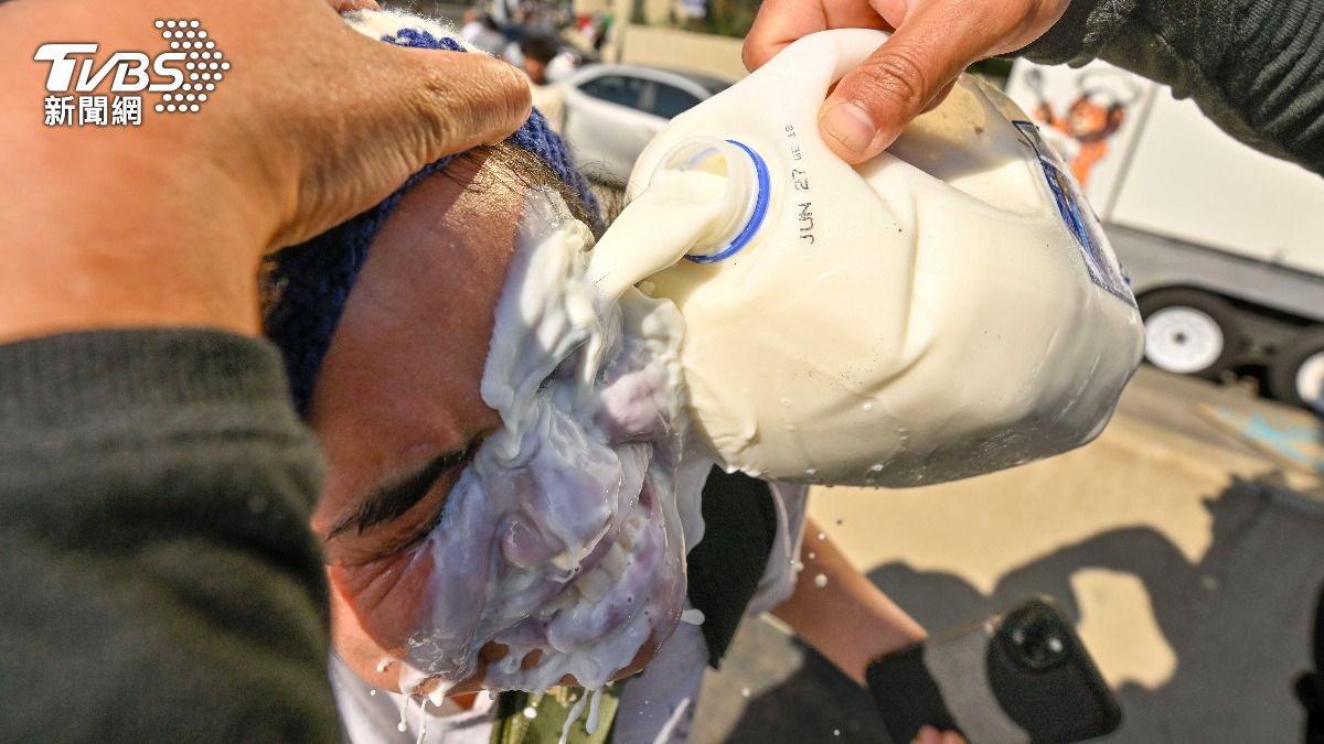 美國洛杉磯移民示威陷入混亂，街上催淚瓦斯煙霧迷漫，不少抗議者在路邊用水或牛奶洗臉。（圖／達志影像美聯社）
