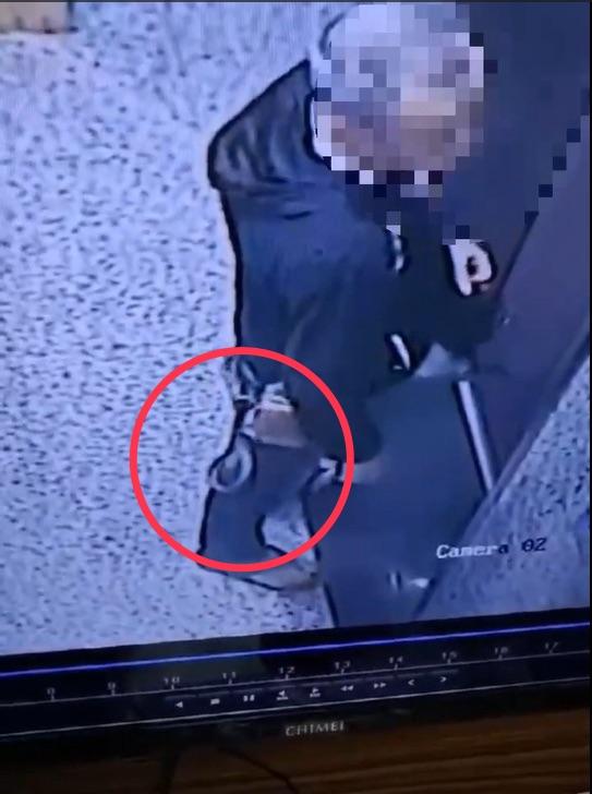 腰包帶著一條蛇進入電梯，男子渾然不知。（圖／社區主委提供）
