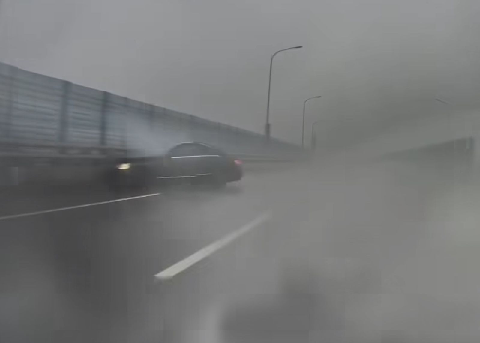 賓士駕駛在發現後車無意「對戰」後似乎自行加速駛離,熟不知一分鐘後,該輛賓士在積水彎道路段打滑失控,自撞外側護欄。(圖/翻攝自「爆料公社」)