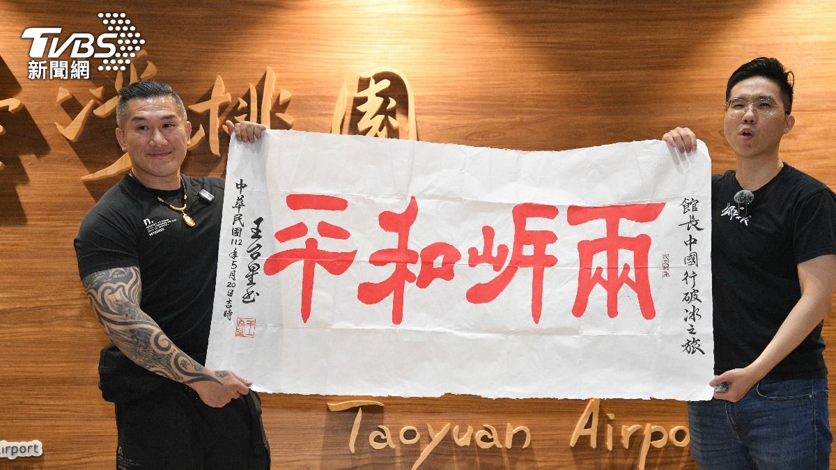 館長與「歷史哥」李易修,高舉兩岸和平布條。(圖/胡瑞麒攝)